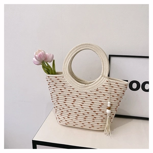 Detail of woven straw tote bag featuring brown polka dots and a large circular handle
