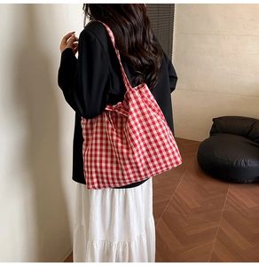 Macro view of red and white checkered canvas tote bag with woven fabric texture