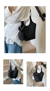 Detail of black lychee grain leather bucket bag with matching mini heart chain pouch