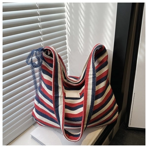 Detail of red and blue striped canvas tote with blue lace trim and faux leather patch