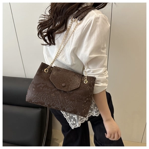 Close-up detail of vintage brown snake pattern leather shoulder bag with gold chain strap