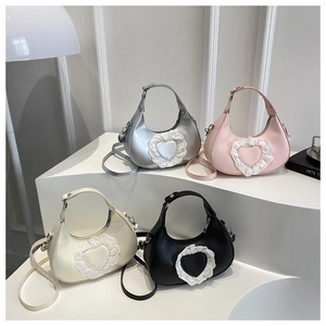 Four colors of heart-shaped lace crescent bags shown on a minimalist white display stand
