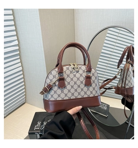 Detail of vintage shell bag with retro monogram pattern and elegant leather handles