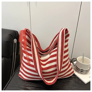 Détail d'un sac cabas en toile à rayures rouges et blanches avec bordure en dentelle