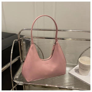 Pink crescent shoulder bag with FASHION logo placed on a metallic cart near a coffee cup