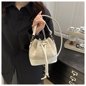 Detail of the woven texture and cream leather stitching on the drawstring bucket bag