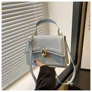 Detail of light blue PU leather handbag with golden ring metal clasp and single handle