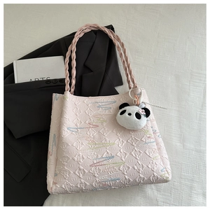 Pink tote bag detail with quilted rhombic patterns and cute panda plush keychain