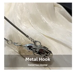 Close-up of a silver lobster clasp hook and snake chain with a hammered texture finish