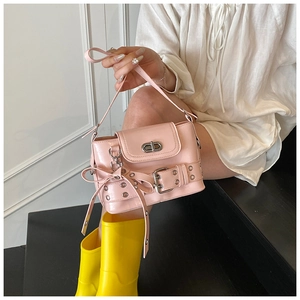Détails du sac à main rose style Y2K avec œillets argentés et nœuds sur les côtés