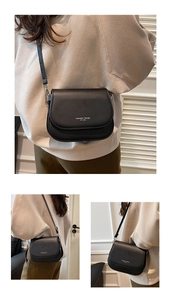 Detail view of black leather crossbody saddle bag with Fashion Trend printed text