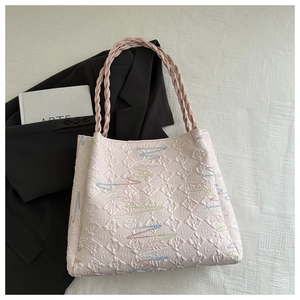 Detailed close-up of pink bucket bag featuring quilted texture and braided strap design