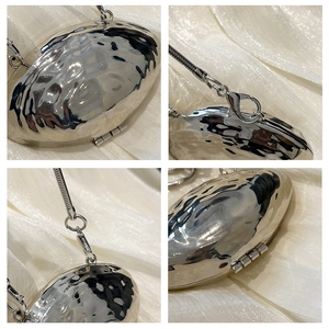 Detailed views of a silver metallic shell evening bag with fluid hammered texture and chain