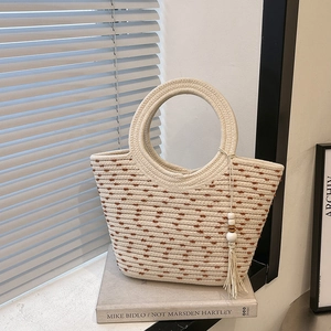 Chic cream woven tote bag with brown dot texture and tassel charm for summer vacations