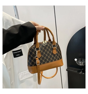 Detail of shell-shaped handbag showing vintage monogram canvas and brown leather handle
