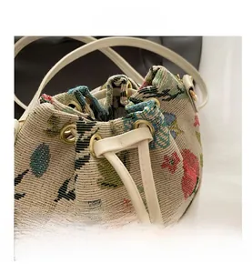 Detail of floral knit bucket bag showing textured fabric and leather drawstring closure