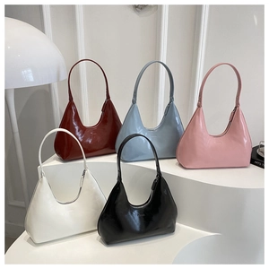 Multiple glossy leather hobo bags in assorted colors displayed on a white tiered stand