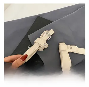 Detail of adjustable litchi texture leather shoulder strap with silver buckle