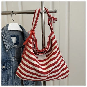 Detail of red and white striped woven tote bag with knotted shoulder strap and patch