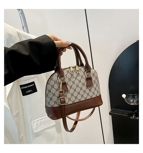 Detail of vintage shell bag with brown faux leather trim and adjustable shoulder strap