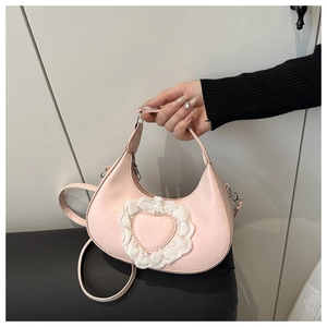 Dettaglio borsa in pelle PU rosa con cuore di pizzo bianco e tracolla regolabile