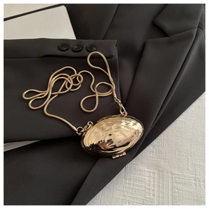 Détail du sac de soirée en métal doré en forme de coquillage avec finition miroir brillant