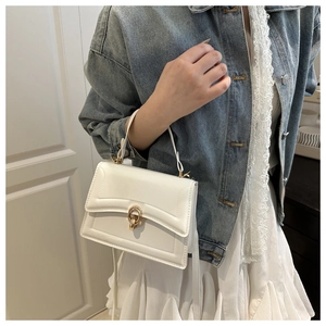 Detail of white leather handbag featuring elegant gold double-ring buckle and handle