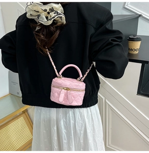 Detailed back view of model wearing a pink quilted mini bag with gold chain strap
