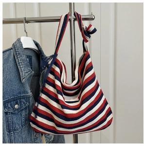 Detail view of colorful striped canvas tote bag with elegant dark blue lace shoulder strap