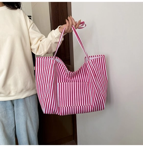 Detail of red and white striped canvas tote bag with front pocket and large capacity