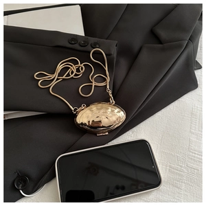Détail du mini sac de soirée doré en forme de coquillage avec chaîne serpent