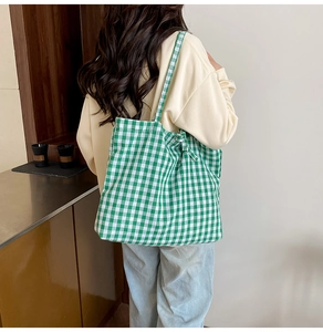Detail of green and white plaid tote bag showing its large capacity and soft canvas fabric
