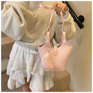 Detail of pink lychee leather bucket bag with silver chain and matching mini pouch
