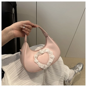 Dettaglio borsa a mezzaluna rosa con toppa a cuore in pizzo bianco e pelle PU liscia