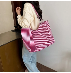 Red and white striped canvas tote bag detail showing large front pocket and spacious design