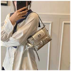 Détail d'un sac à main argenté métallisé avec pendentif noeud et fermoir en métal vintage