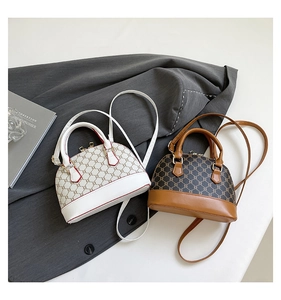 Detailed top view of vintage shell-shaped crossbody bags in white and brown with chain pattern