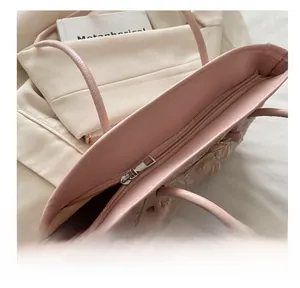 Close-up of a premium smooth silver zipper on a pink leather tote with floral appliques