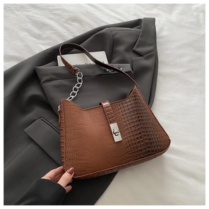 Close-up of brown crocodile texture shoulder bag with silver metal twist lock detail