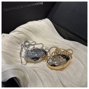 Detailed close-up of gold and silver shell-shaped mini bags with sleek snake chains