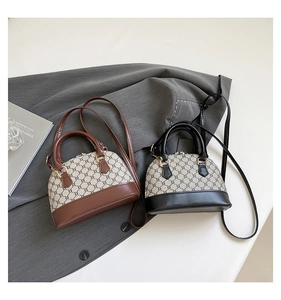 Detailed close-up of shell-shaped canvas bags with leather trim and gold chain print