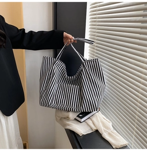 Close-up of a striped canvas tote bag with a long shoulder strap for casual wear