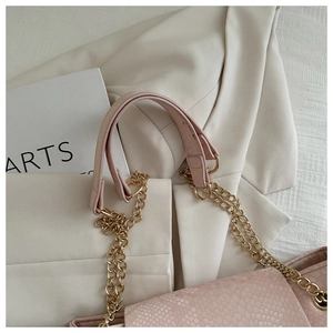Détail du sac à bandoulière rose texture serpent avec chaîne dorée et cuir PU de luxe