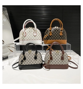 Detail of four retro monogram shell bags in various colors on professional display