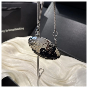 Macro view of silver lava-textured oval pendant with high-shine metallic finish