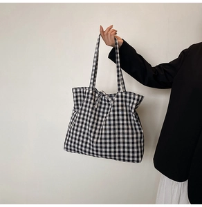 Detail of black and white checkered canvas tote bag with shoulder straps for women