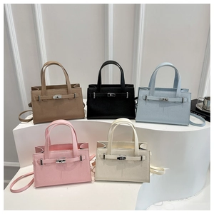 Litchi pattern leather handbags in five colors displayed on white curved pedestals