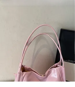 Detailaufnahme der rosa Lackleder-Tote Bag mit glänzender Textur und schmalem Trageriemen