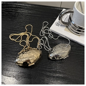 Detail of champagne gold and silver metallic shell bags with wavy texture and snake chains