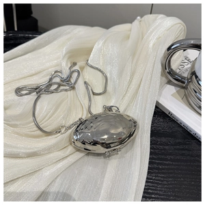 Detailed view of a silver shell-shaped mini metal bag with a sleek snake chain strap